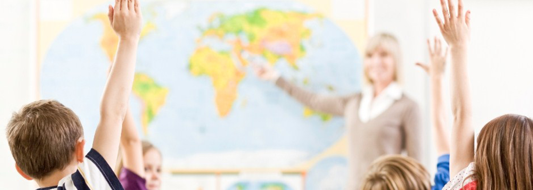 Een juf voor de klas en scholieren met de hand in de lucht