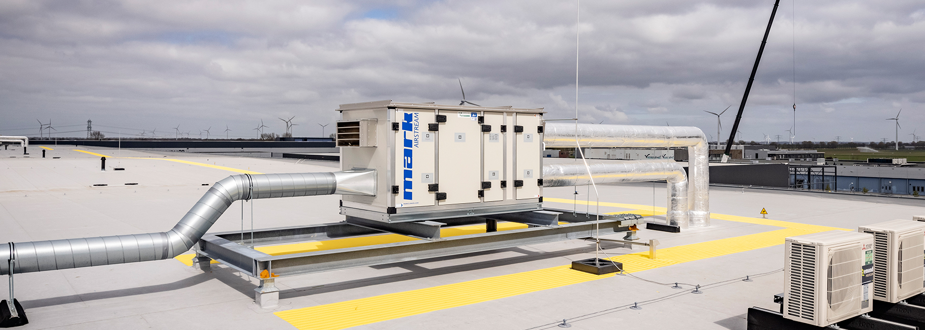 Een Mark Airstream WTW unit met luchtkanalen geïnstalleerd op een dak