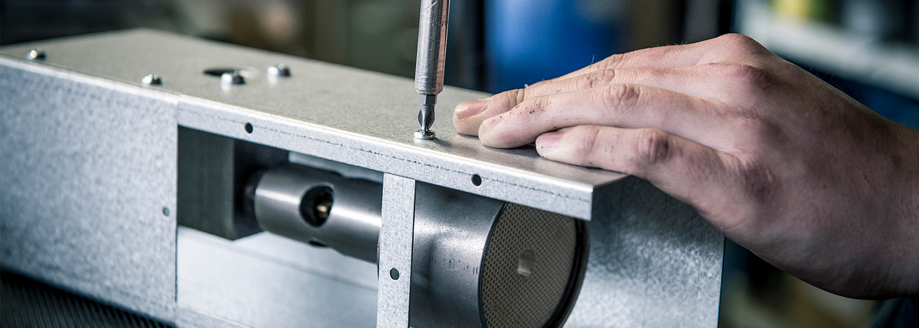 Een productiemedewerker assembleert een onderdeel van een Mark klimaattoestel