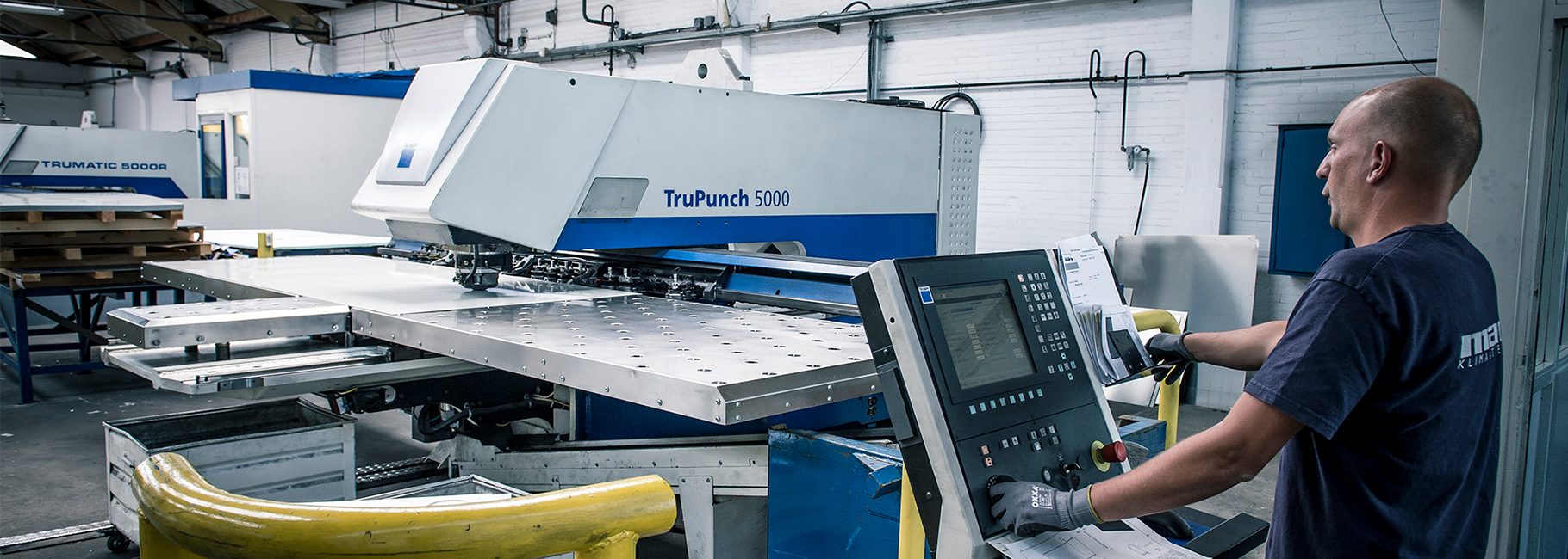 Een productiemedewerker van Mark Climate Technology bediend een TruPunch ponsmachine
